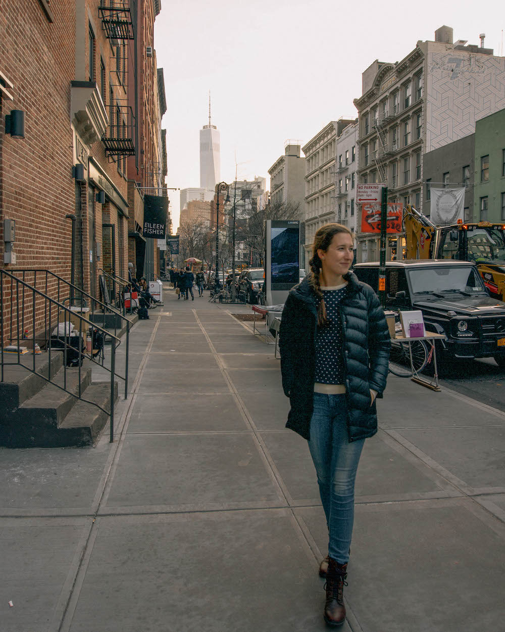 Woman gazing to the side, standing on a SoHo street. 