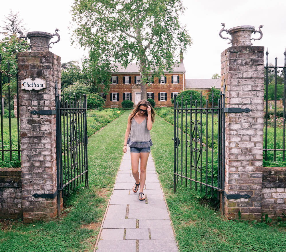 Woman posing in front of Chatham Manor. 