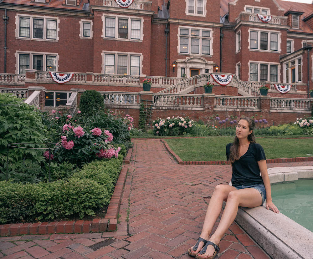 Woman sitting on the edge of the fountain in the garden of the historic Glensheen Mansion. 