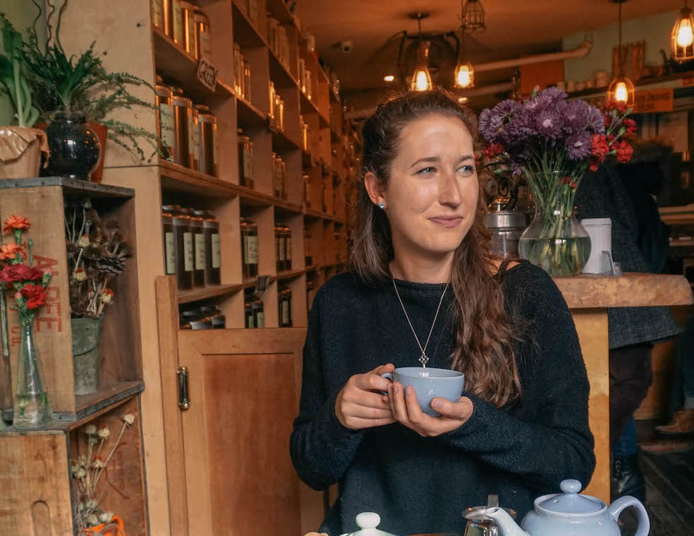 woman holding blue coffee mug