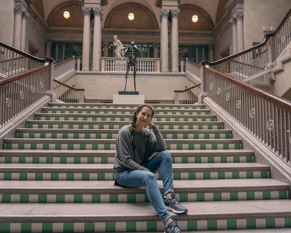 Woman sitting on the steps inside the Art Institute in Chicago. 