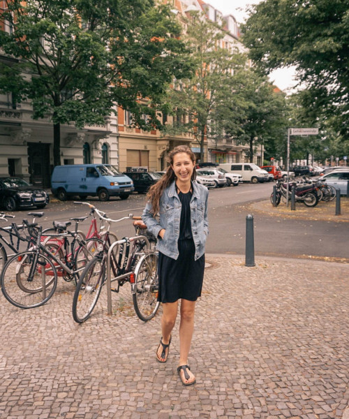 A woman smiling on a street in Berlin.