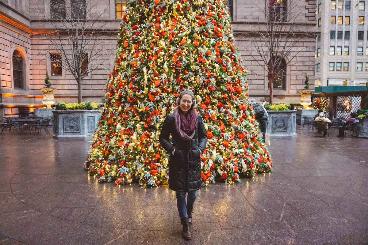 Woman standing in front of Lotte Palace Hotel Christmas Tree in NYC. 