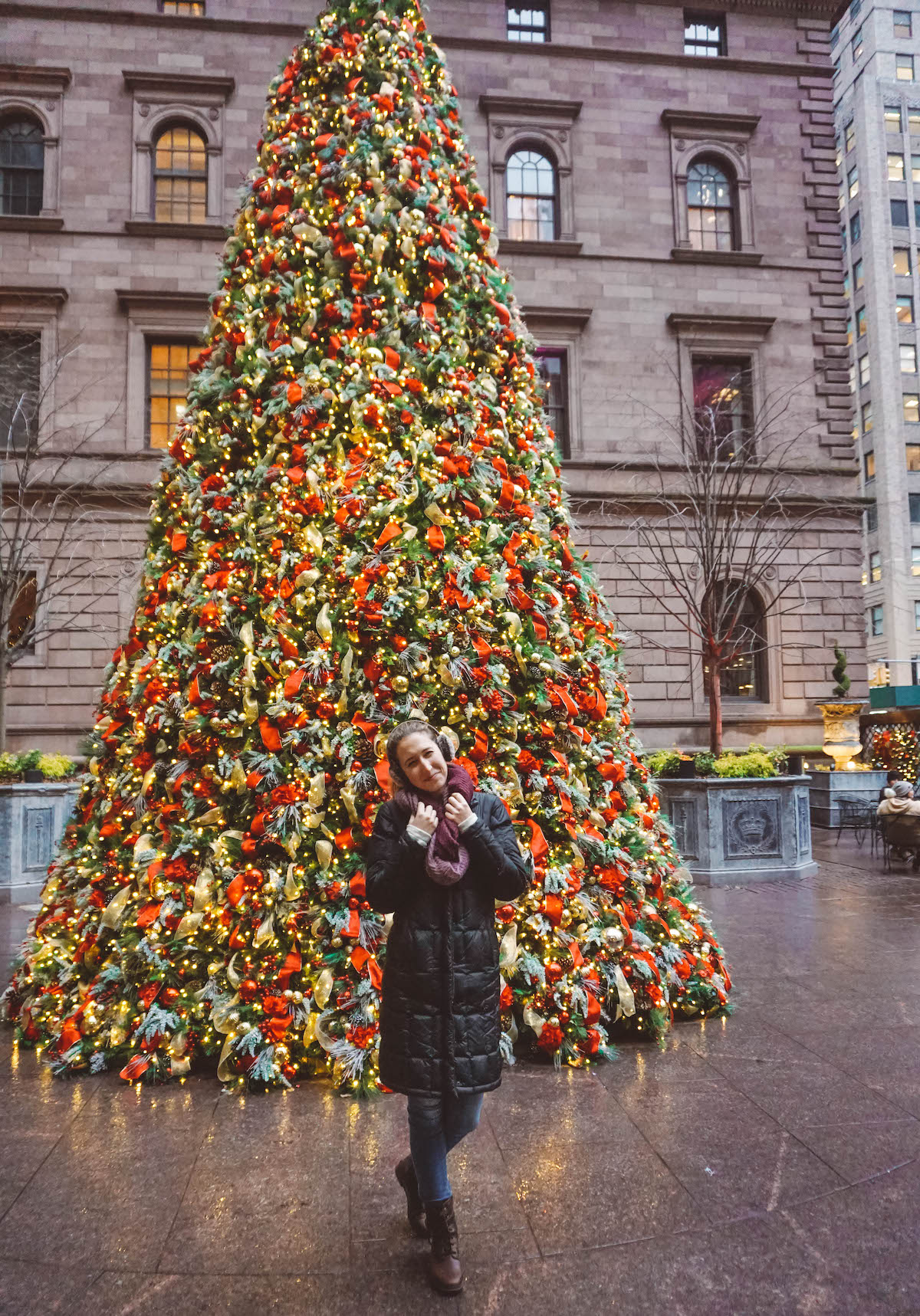 Woman standing in front of lit Lotte Palace Hotel Christmas tree.