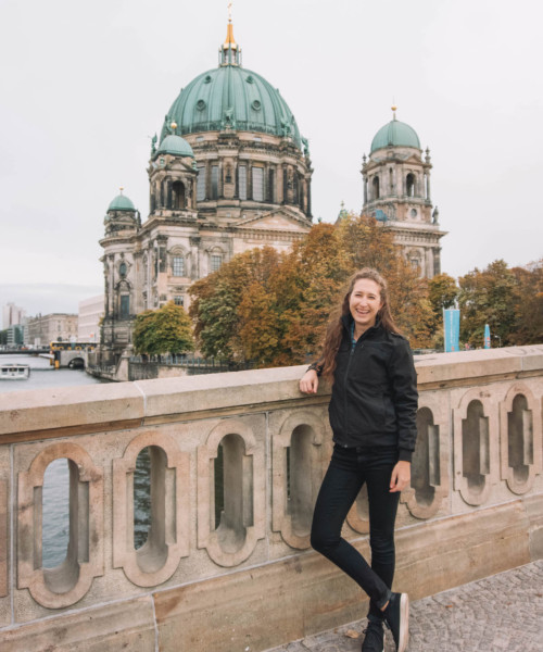 Woman smiling on a bridge in front of the Berliner Dom.