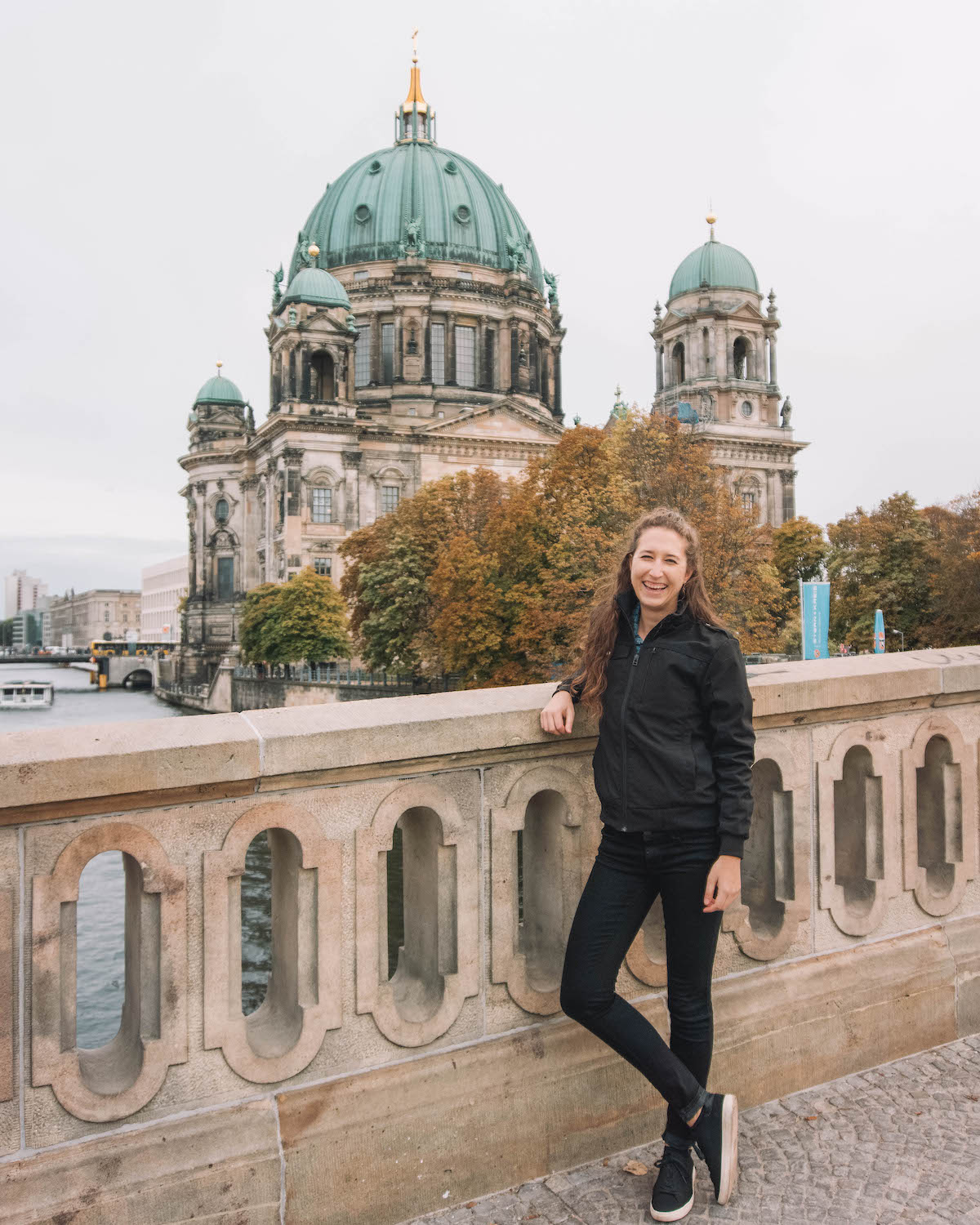 Woman smiling on a bridge in front of the Berliner Dom.