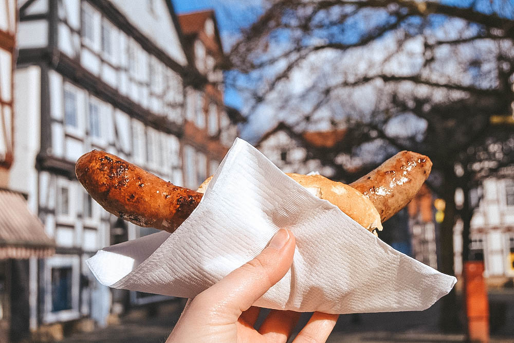 A bratwurst being held aloft