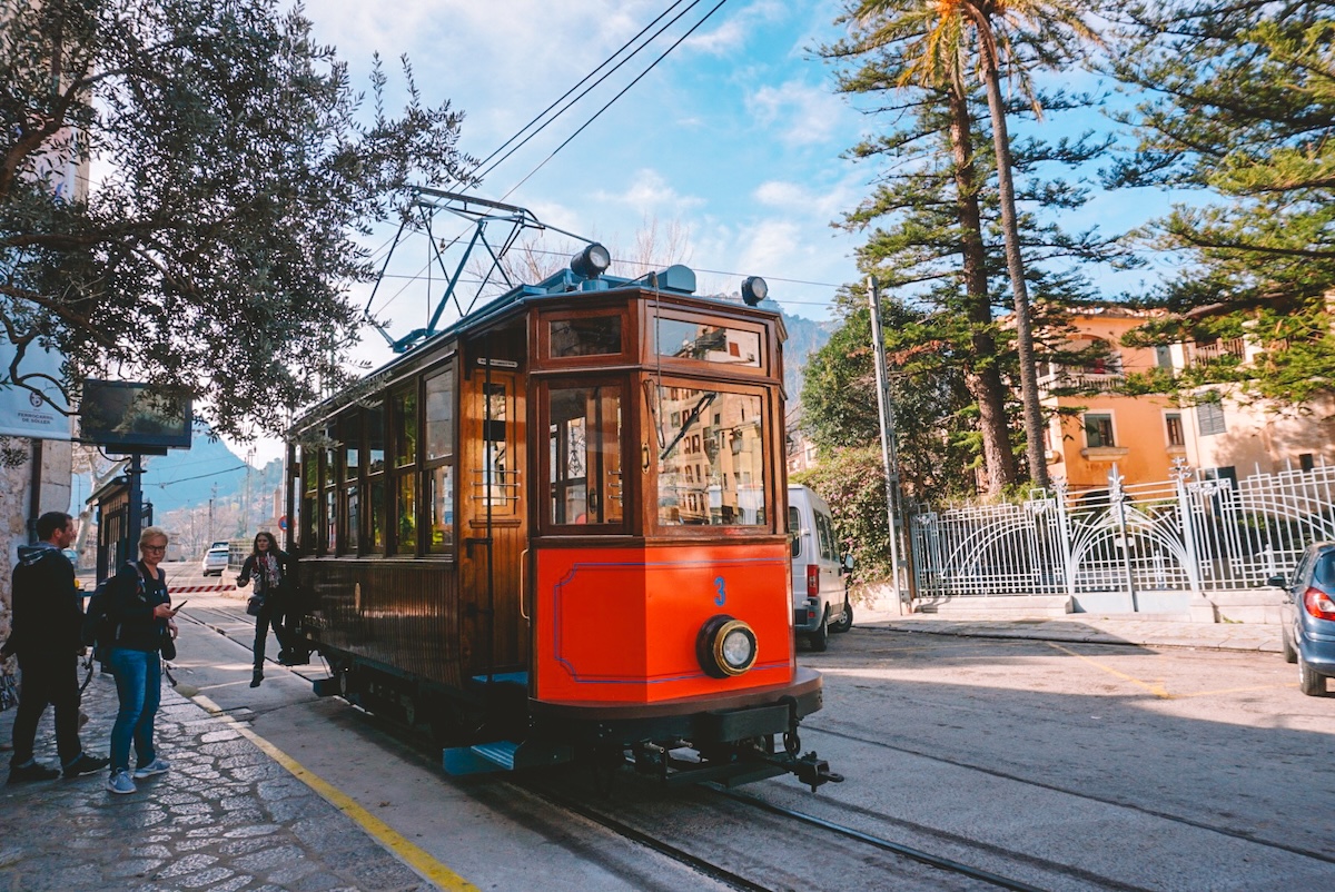 A historic tram driving through Polença on Mallorca.