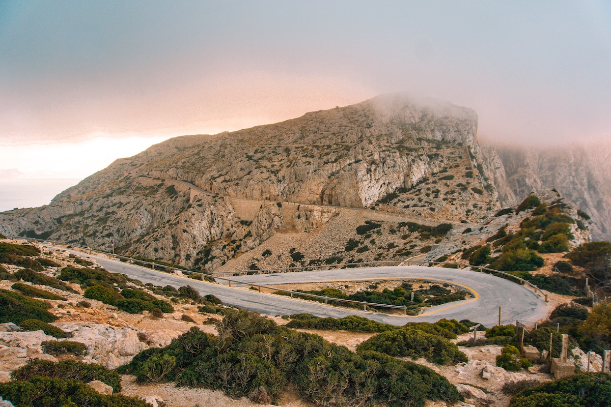 A foggy sunset view of the road leading to the Cap de Formentor Lighthouse on Mallorca.