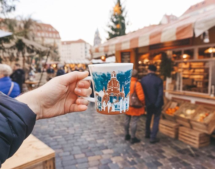 A Christmas market mug being held aloft.