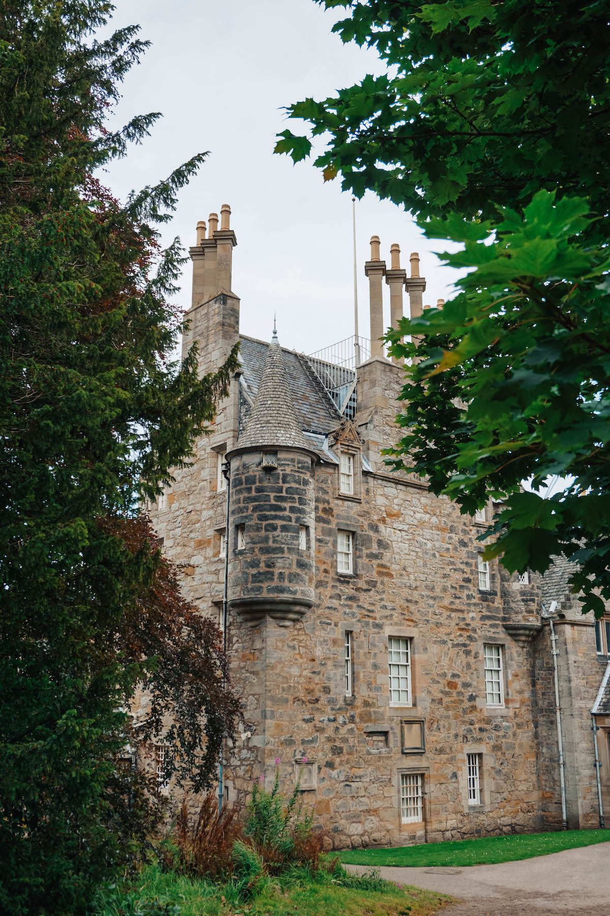 The side of Lauriston Castle, viewed through green foliage. 