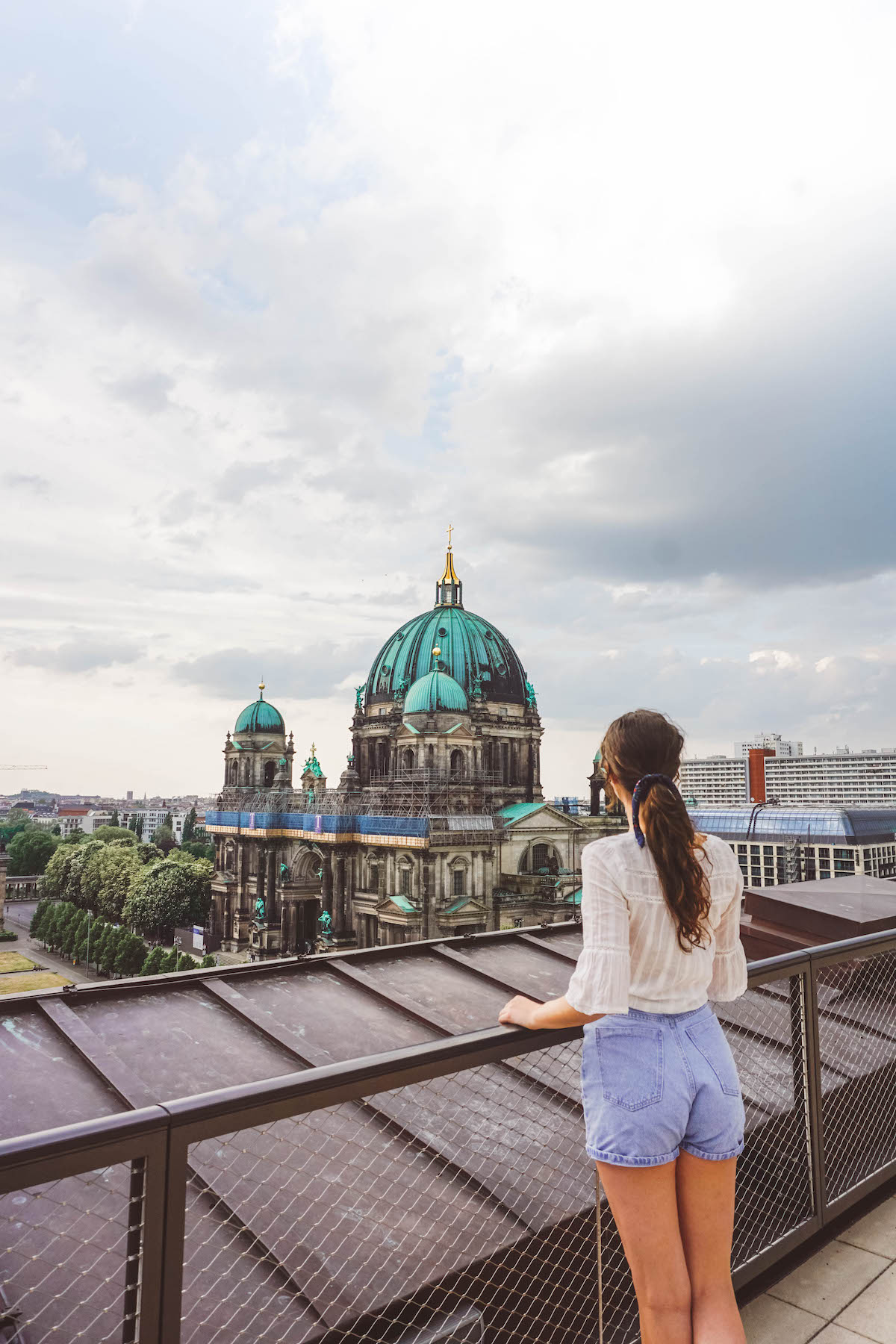 A woman gazing out at the Berliner Dom, from the top of the Humboldt Forum. 