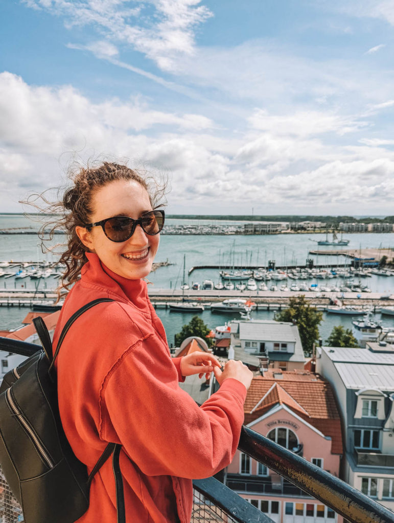 A woman smiling from atop the Warnemünde lighthouse