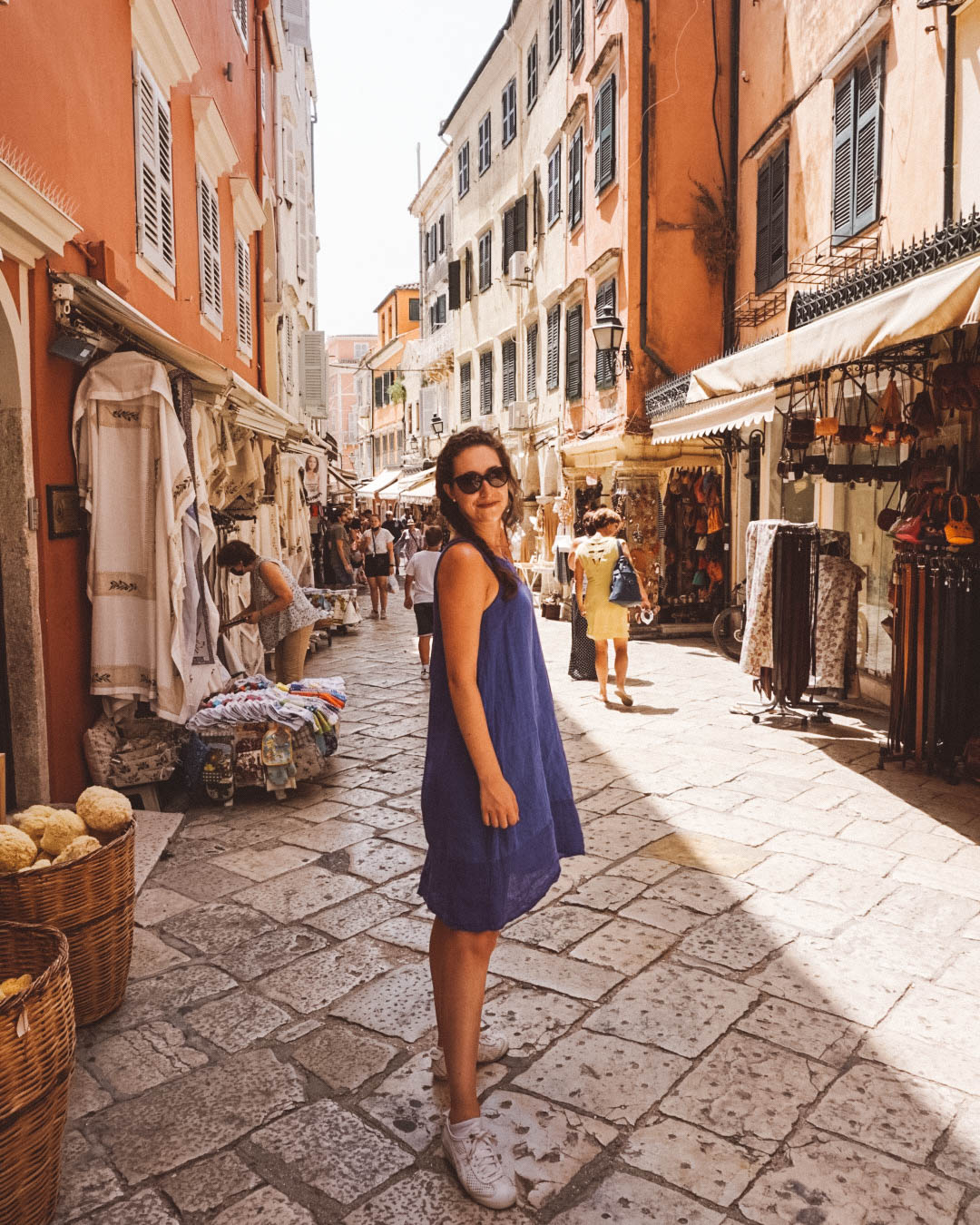 Woman in blue dress smiling in Corfu Old Town.