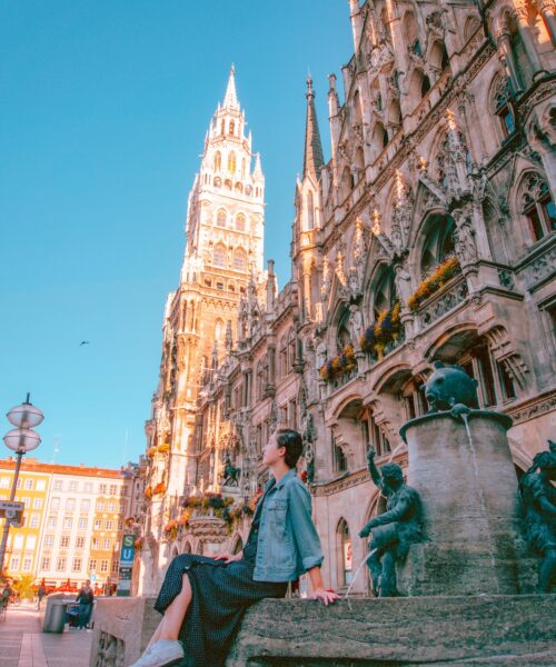 Woman sitting on fountain at Marienplatz in Munich.