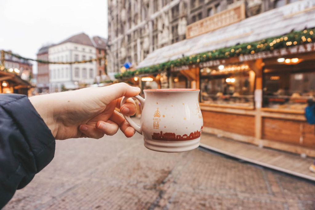 A Christmas market mug being held aloft