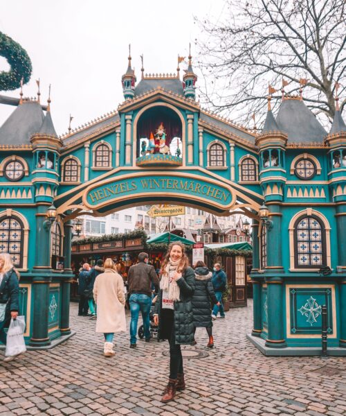 Woman smiling in front of entrance to Heinzels Winter Fairytale