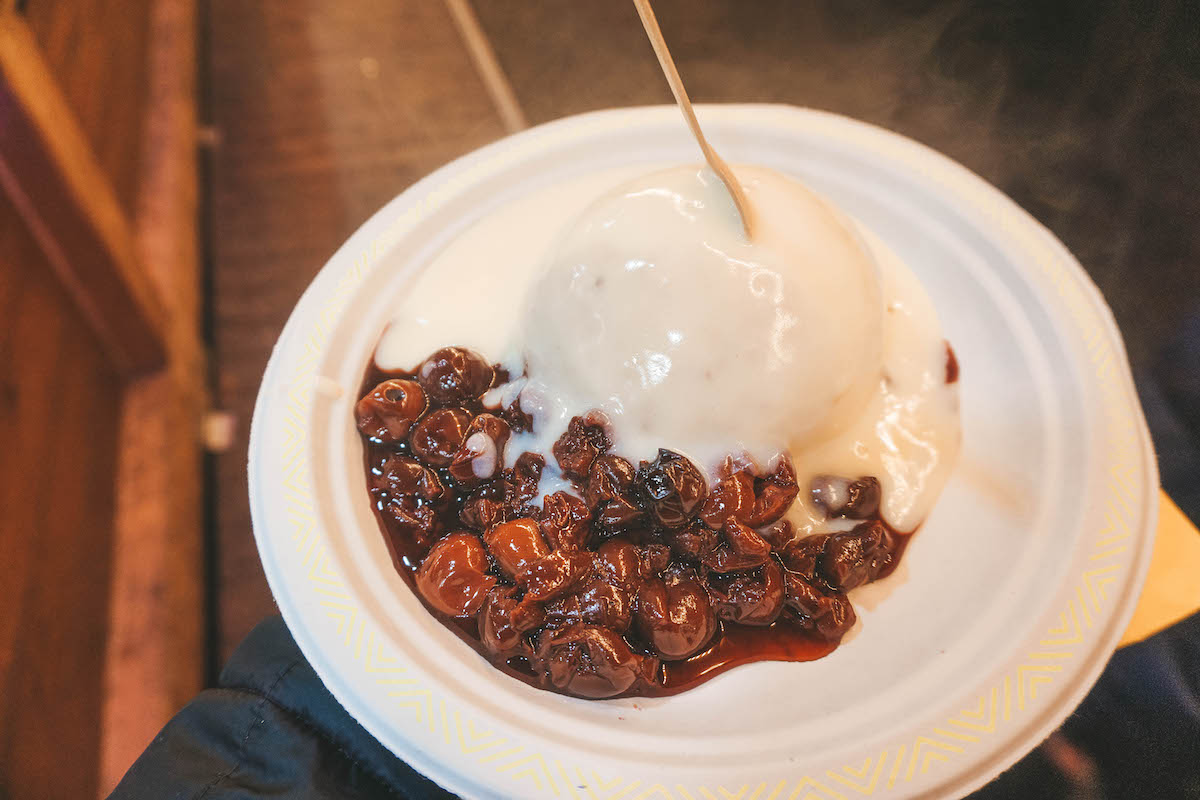 Dampfnudeln with vanilla sauce and cherries on a paper plate