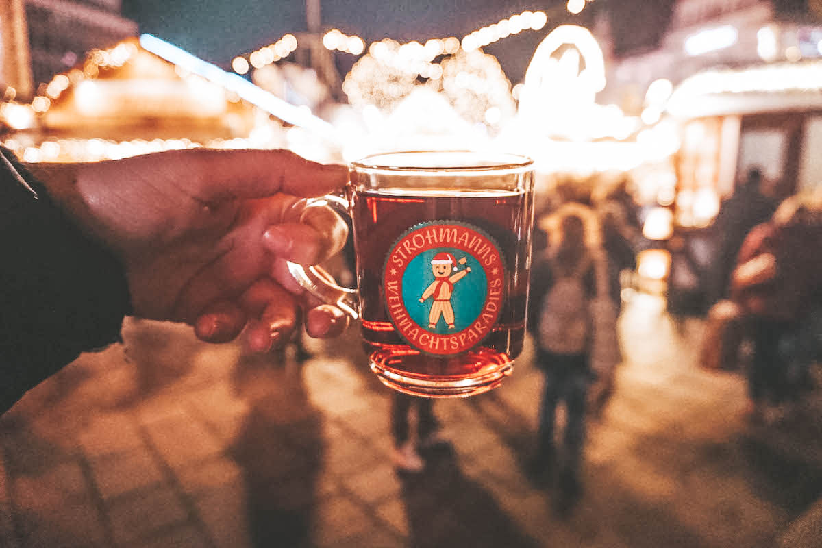 A glass of Glühwein being held aloft