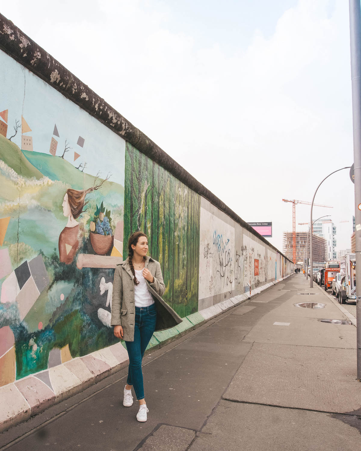 Woman walking along the East Side Gallery in Berlin, Germany. 