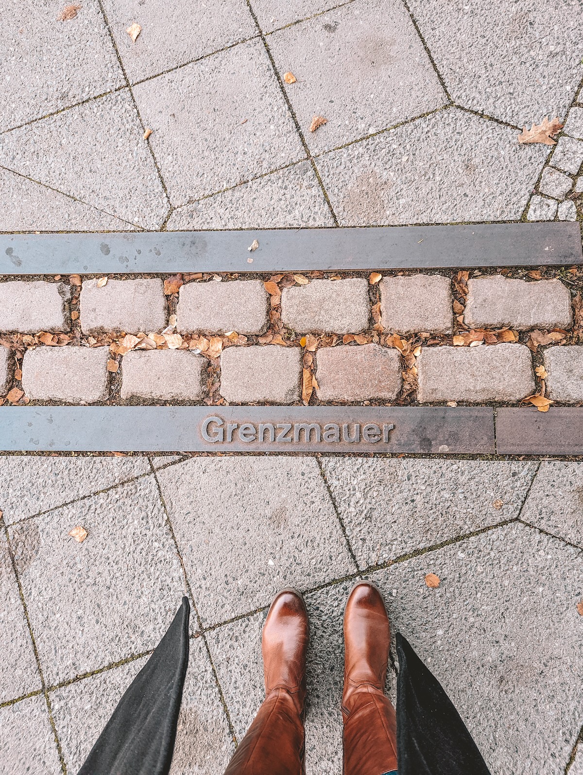 Looking down at a trail of bricks representing the path of the Berlin Wall.