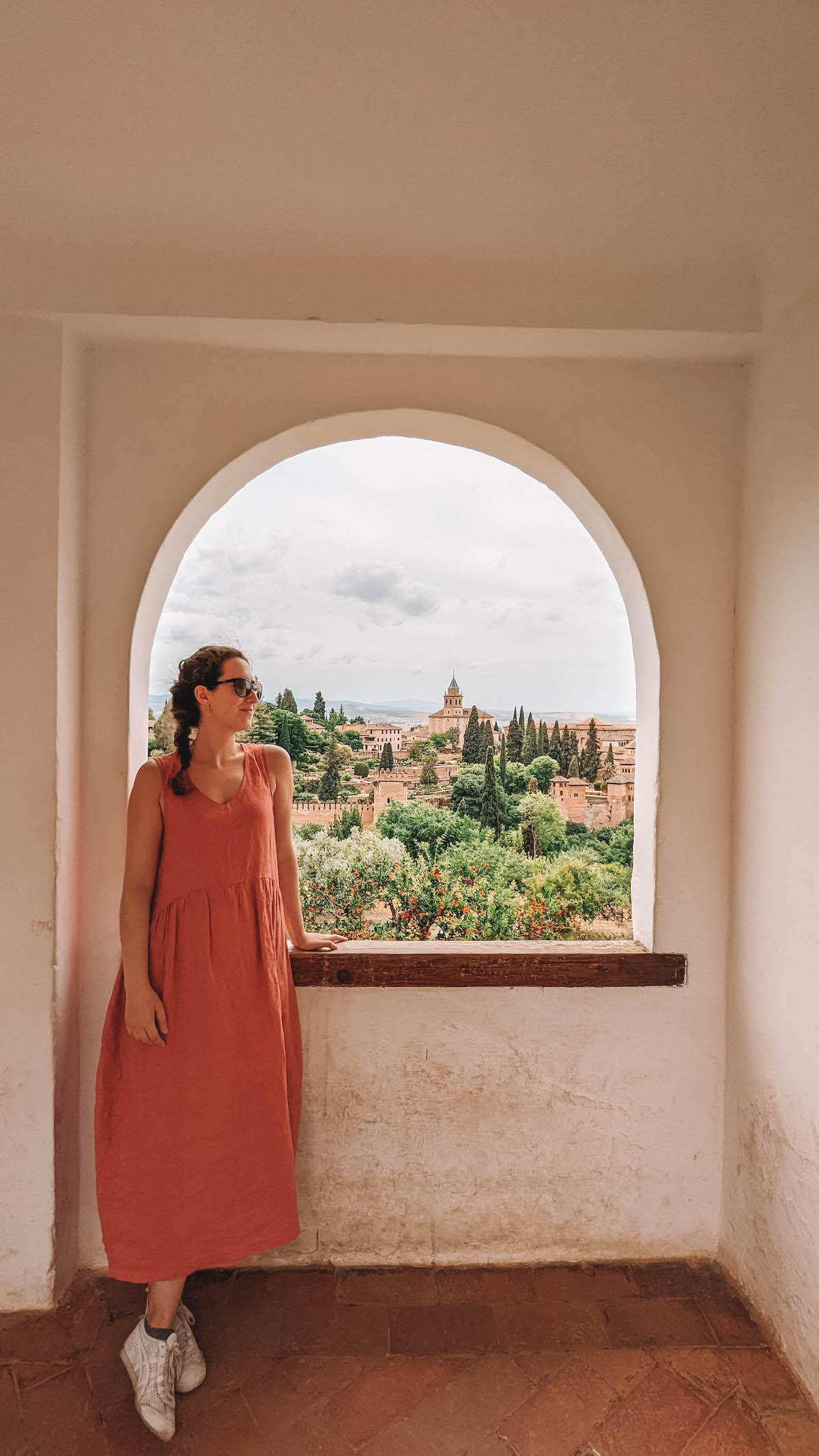 Woman gazing out a window in Generalife in the Alhambra
