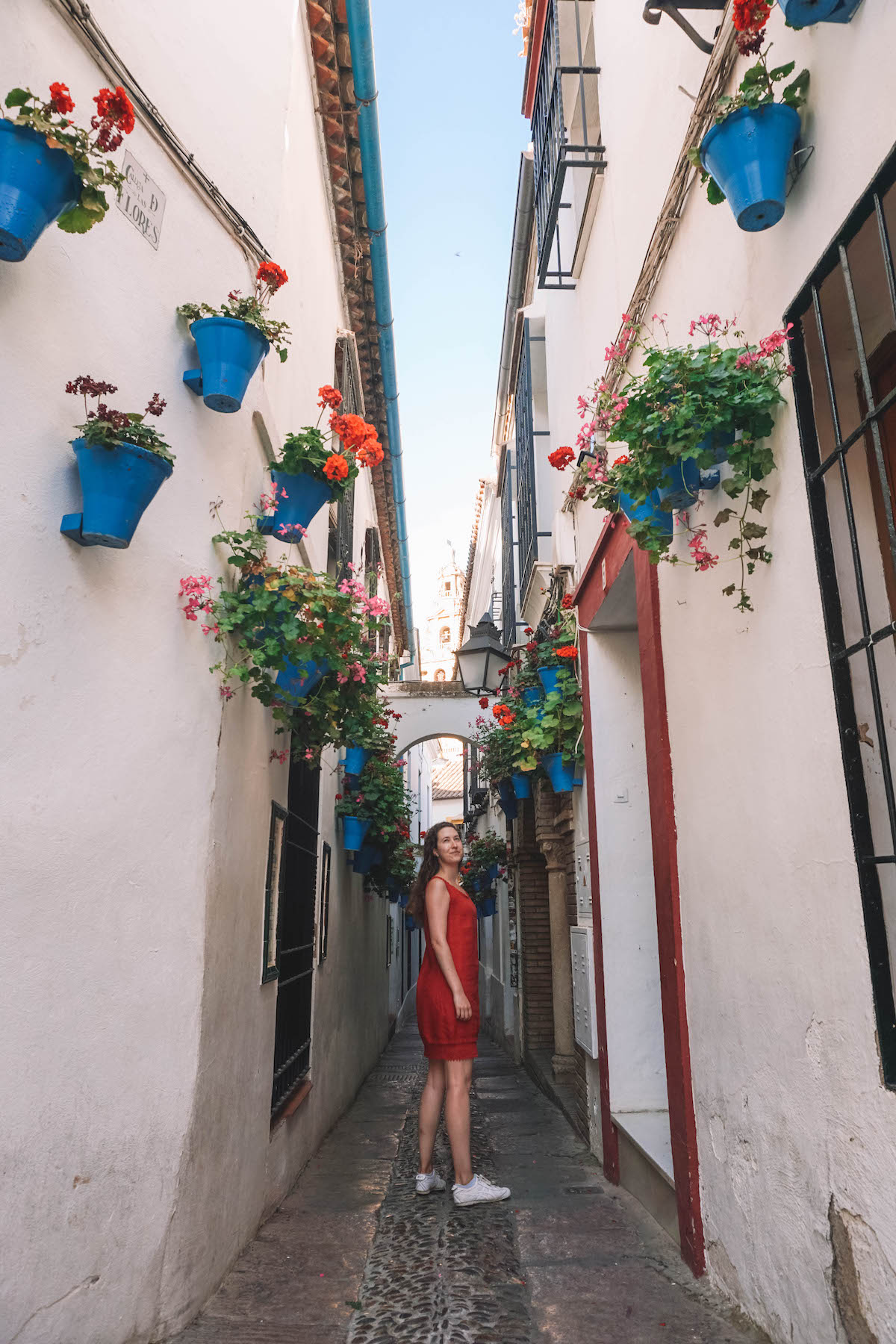 A woman in a red dress standing in Cordoba's Flower Street. 