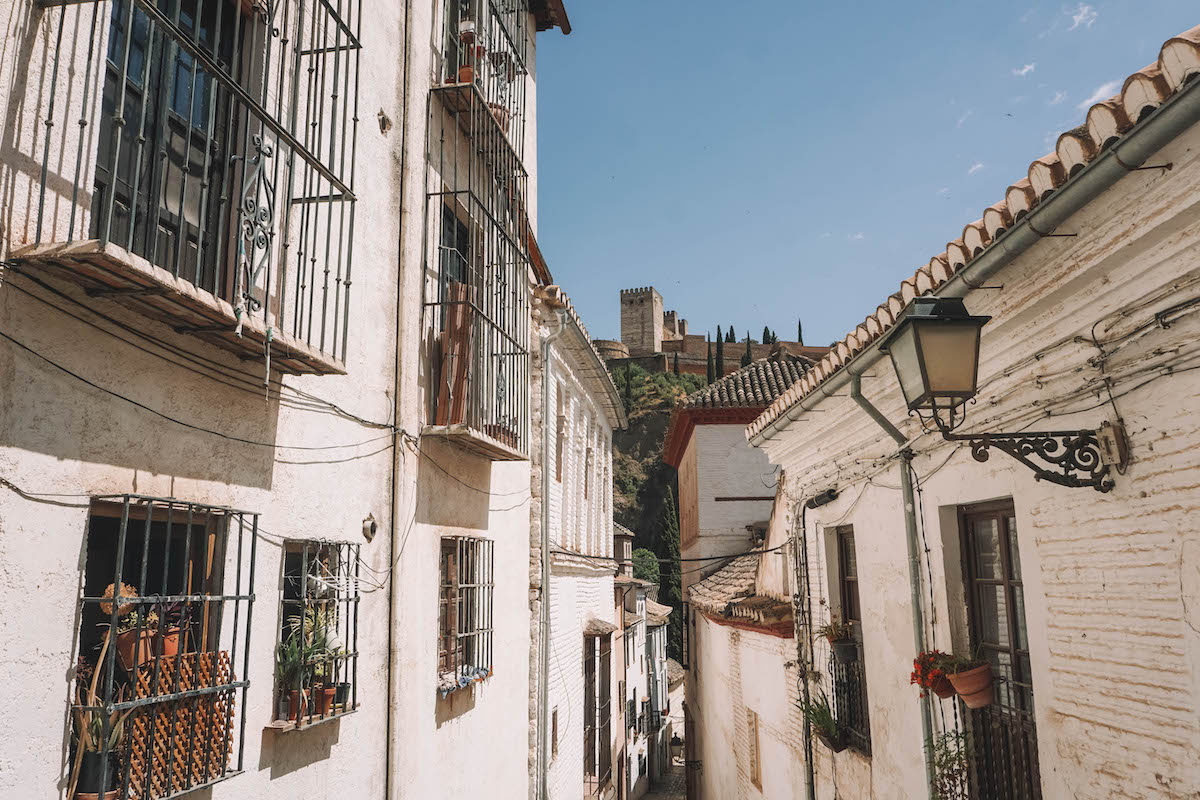 An alley in Albaicin, with the Alhambra in the distance