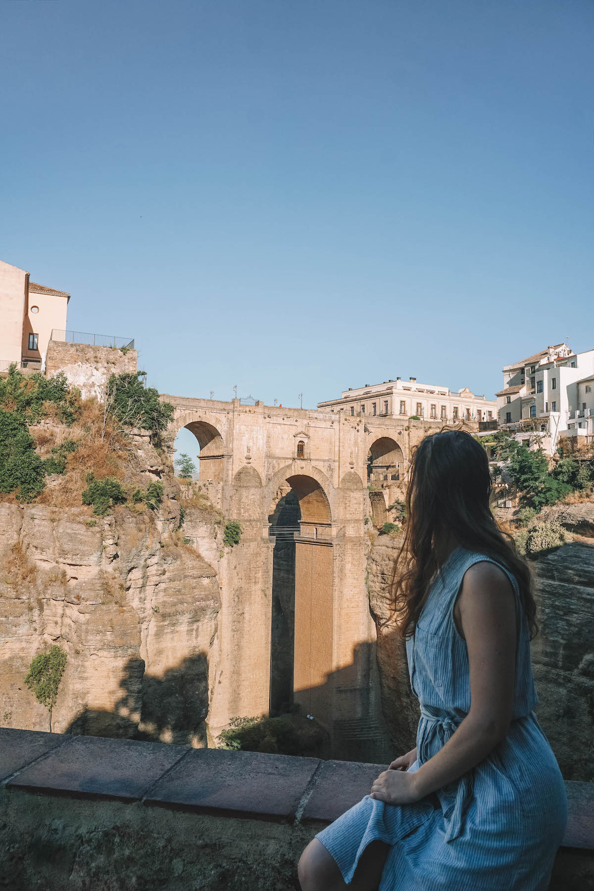 A seated woman overlooking the bridge in Ronda, Spain