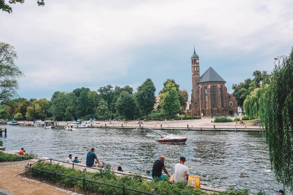 People sitting along the banks of the River Havel. 