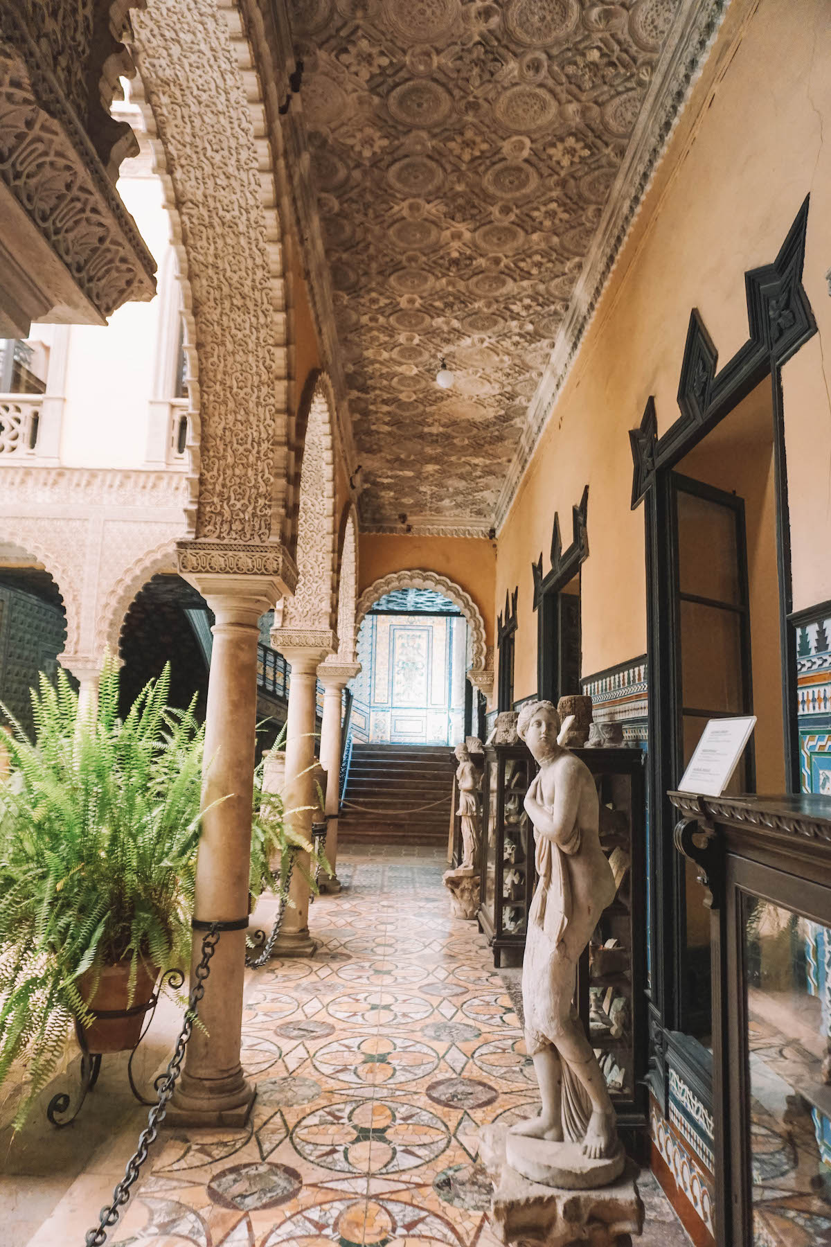 Hallway with statues and plants in Palacio de Lebrija.