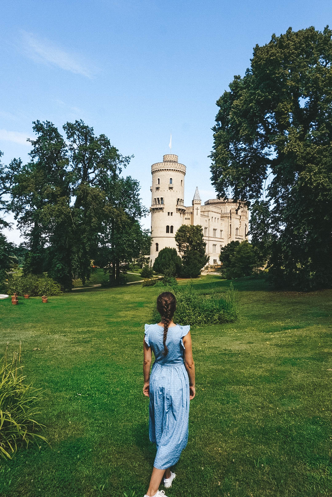 Woman in a blue dress facing Schloss Babelsberg in Potsdam. 