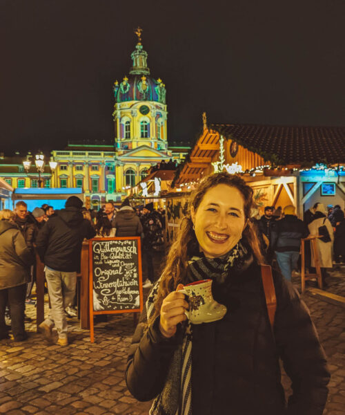 Woman holding mulled wine at the Charlottenburg Palace Christmas Market in Berlin.