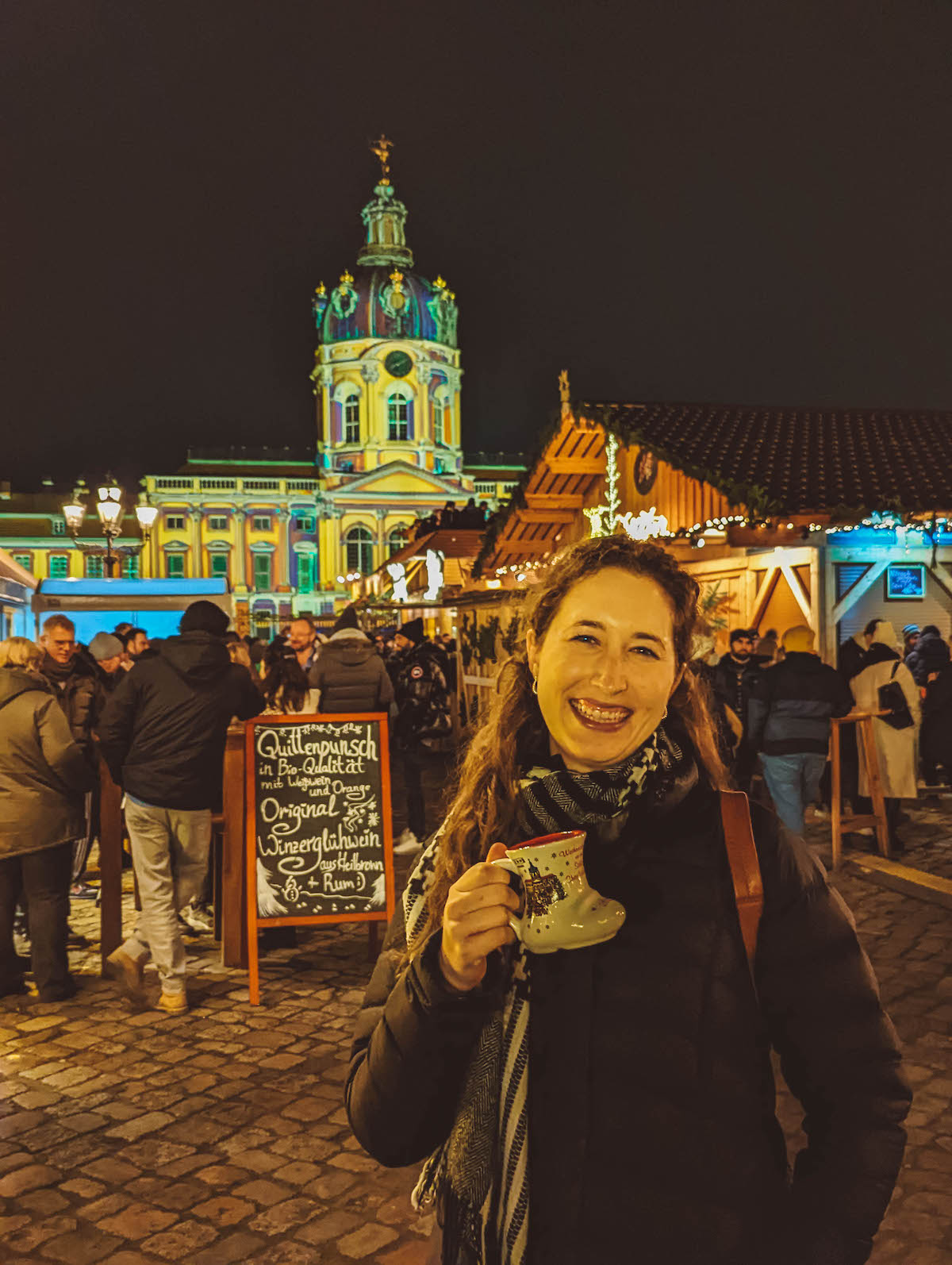 Woman holding mulled wine at the Charlottenburg Palace Christmas Market in Berlin. 