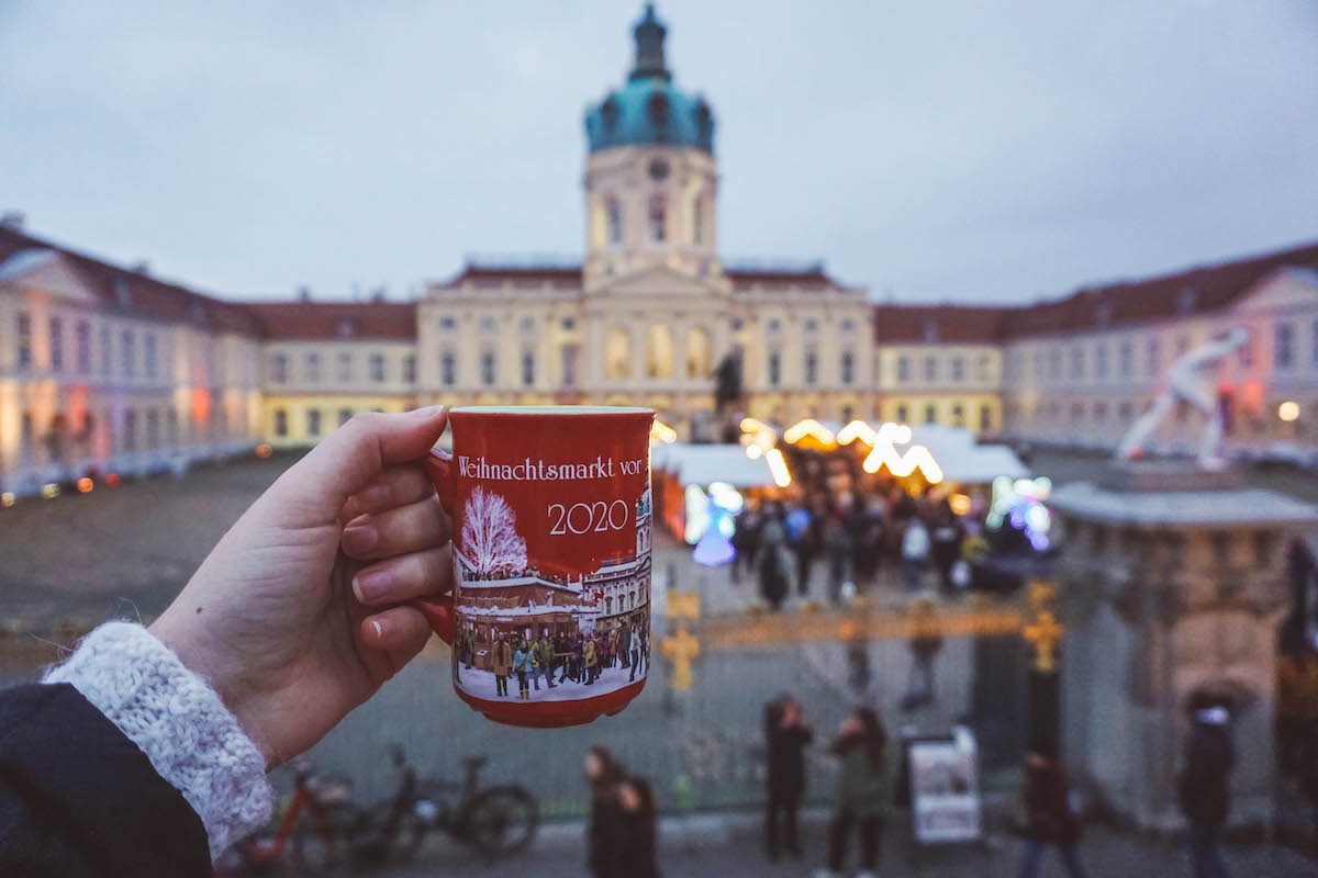 A mug of Glühwein held aloft at the Charlottenburg Palace Christmas market. 