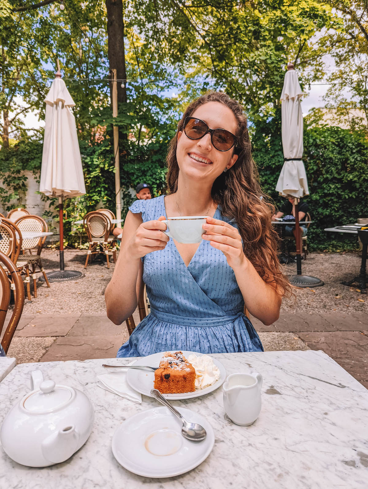 Woman holding teacup and smiling. 