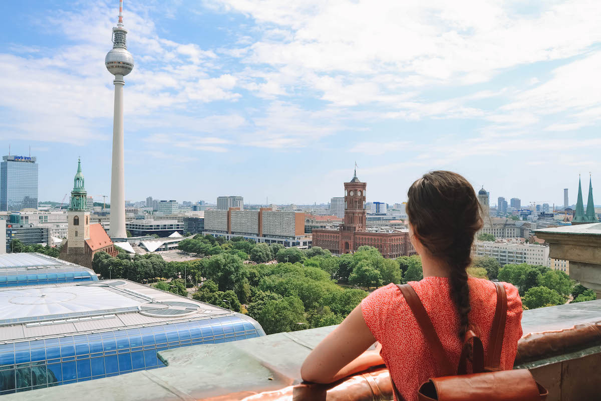 A woman looking out at the Berlin skyline, from the dome of the cathedral.