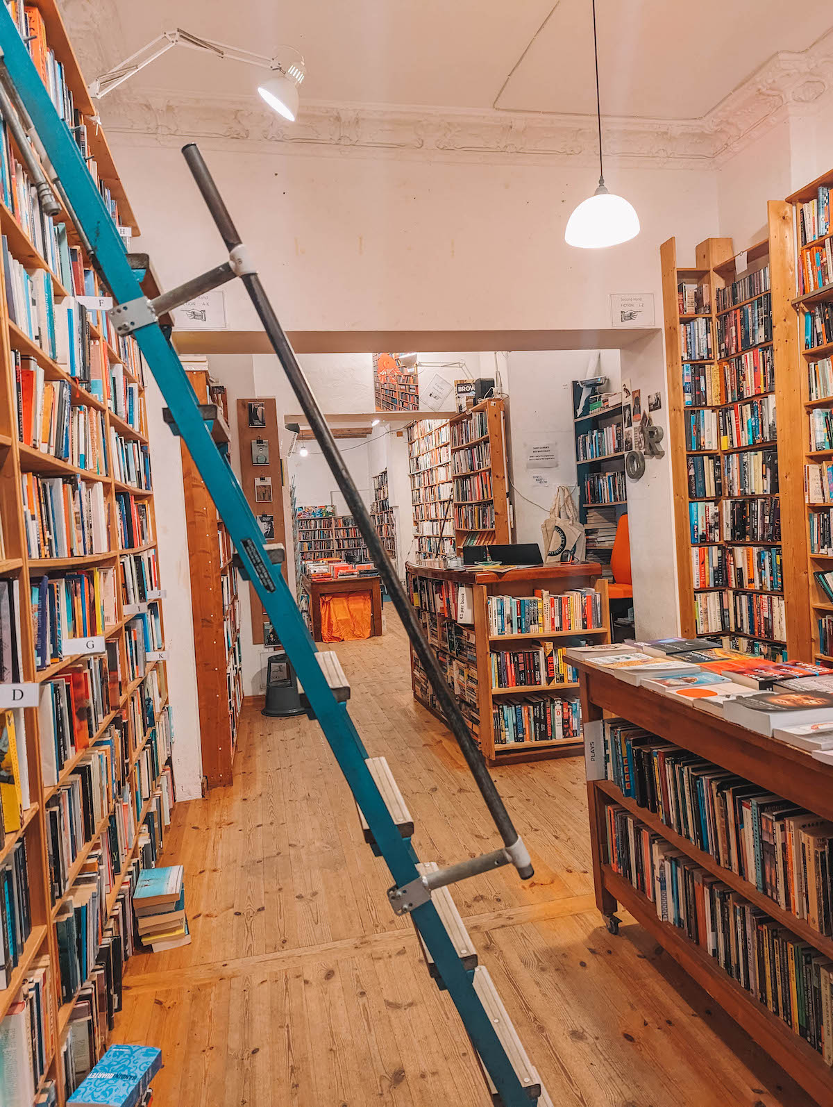 Inside Saint George's English bookstore in Berlin. There are bookshelves and a ladder in the foreground. 