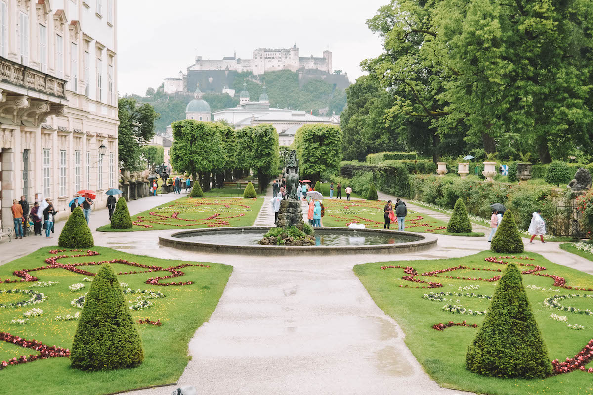 A garden in Salzburg, with the Festung Hohensalzburg on a hill in the distance. 