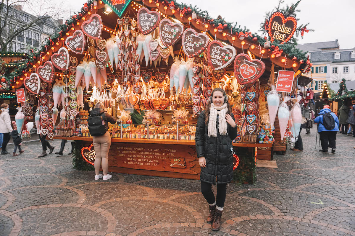 A woman smiling in front of a Lebkuchen stall at the Bonn Christmas market