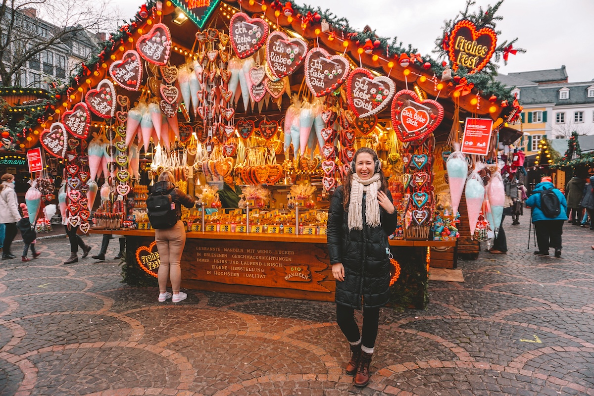 Woman smiling in front of gingerbread stall 