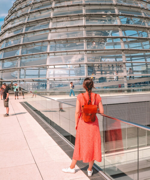 Woman looking at the dome of the Reichstag, on the rooftop.