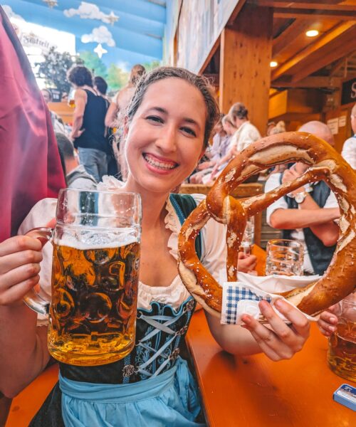 Woman holding beer and pretzel at Oktoberfest