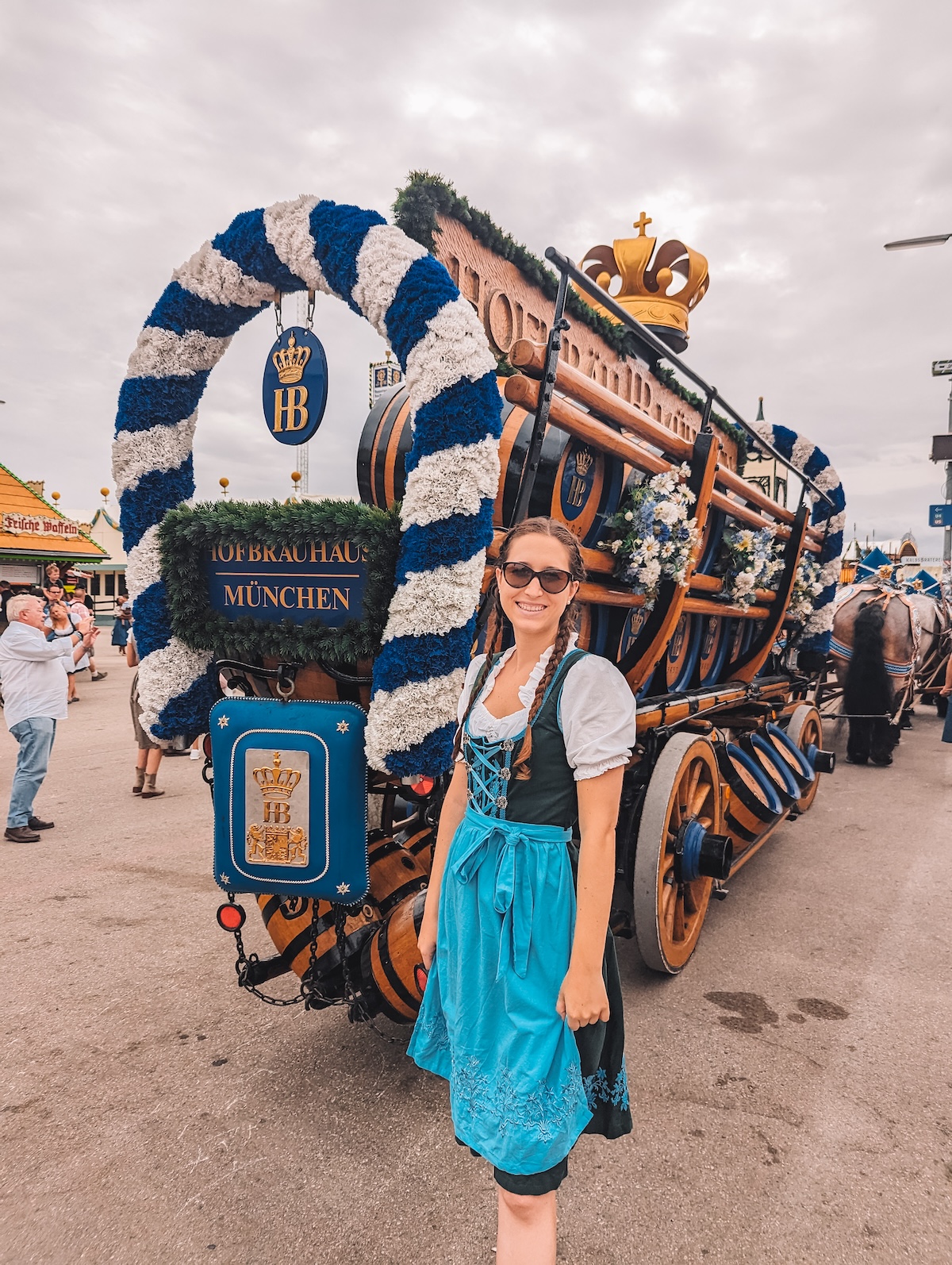 Woman in dirndl posing with Hofbräuhaus horses at Oktoberfest