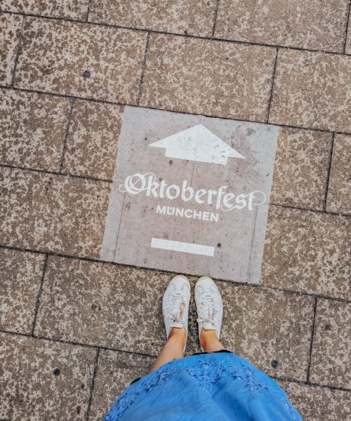 Sign on sidewalk pointing the way to Oktoberfest