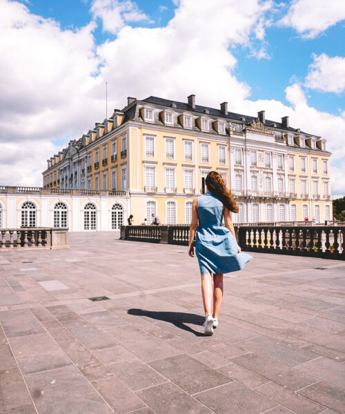 Woman walking toward Augustusburg Palace on terrace