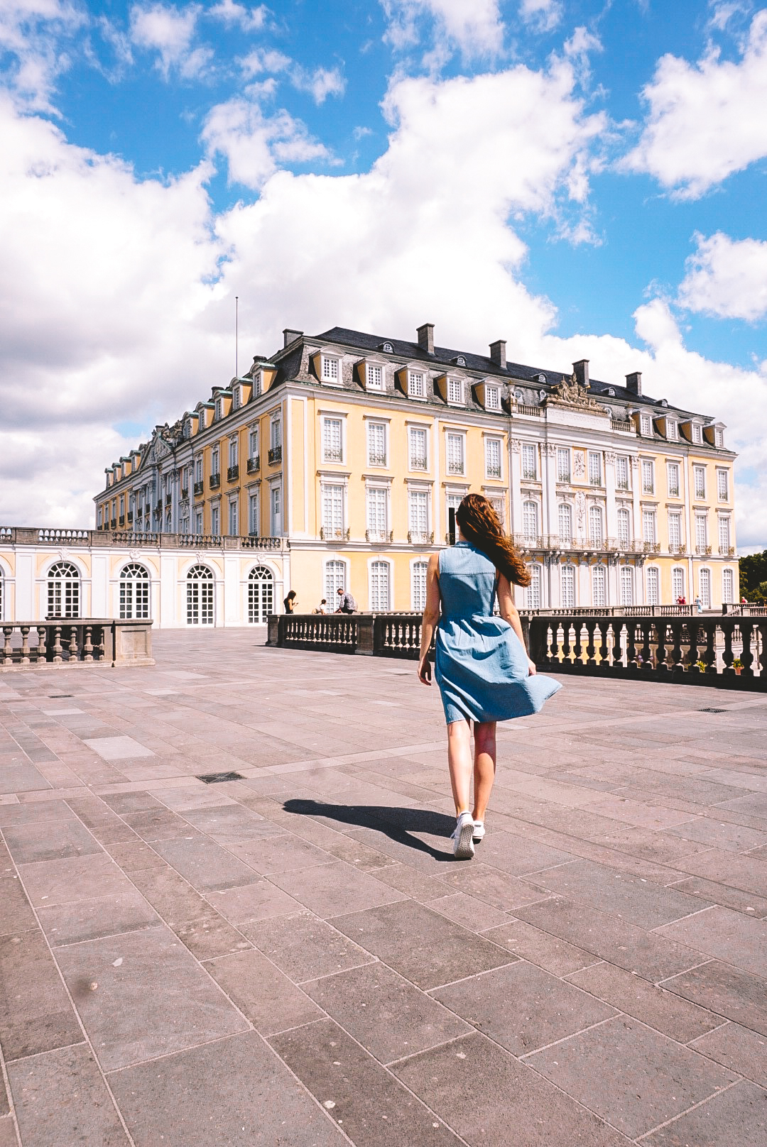 Woman walking toward Augustusburg Palace on terrace
