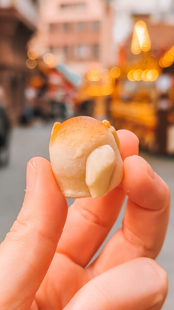 A Frankfurter Bethmännchen cookie held aloft