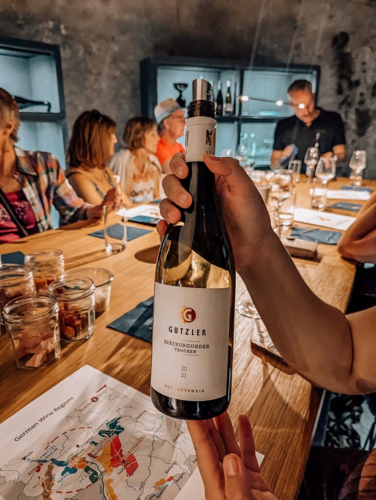 A bottle of red wine held aloft at wine tasting